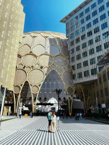a couple standing in front of Expo City in Dubai