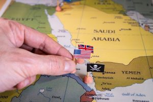 a map of the Middle East with a person placing UK, US and pirate flags
