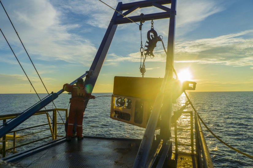 a boat reeling down an autonomous underwater vehicle