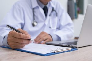 a doctor writing on a notepad